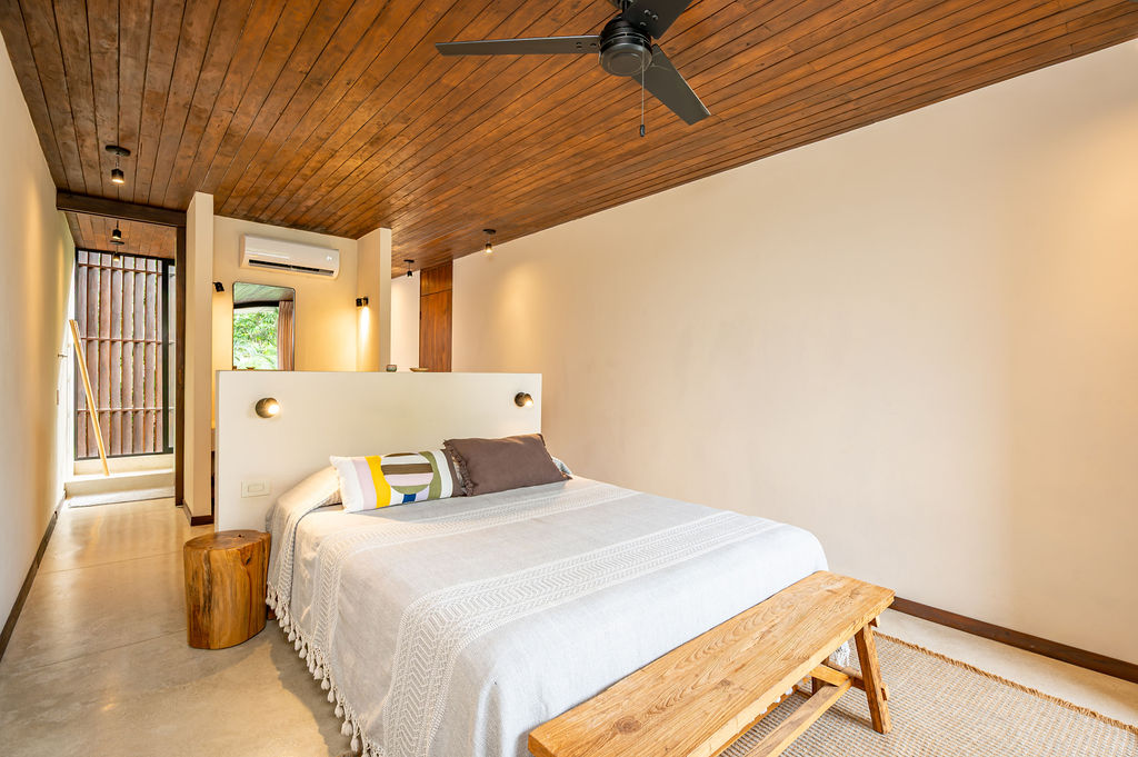 Suite Five — headboard wall and teak bench seen from the balcony